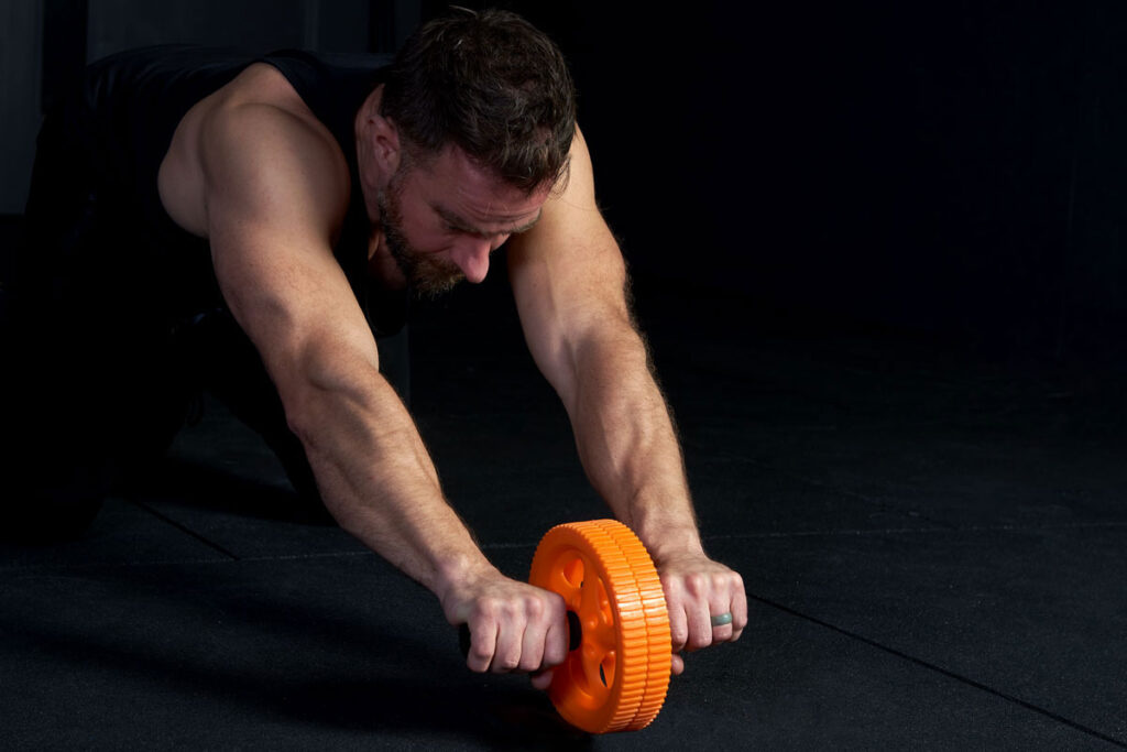 Mirafit Power Ab Roller & Knee Pad Fitness Expert Performing an Ab Roll Out using a Mirafit Power Ab Roller & Knee Pad
