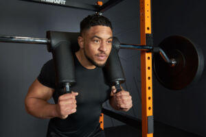 Man squatting while using a Mirafit SSB2 Safety Squat Bar