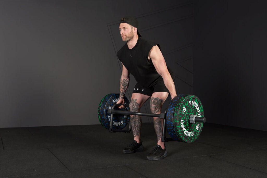 Man performing a Trap Bar Squat with a Mirafit Trap Bar and Colour Splash Bumper Plates