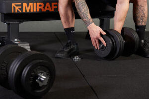 Man grasping Mirafit Cast Iron Adjustable Dumbbells