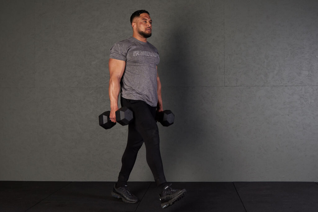 Man performing a farmers walk using Mirafit hex dumbbells
