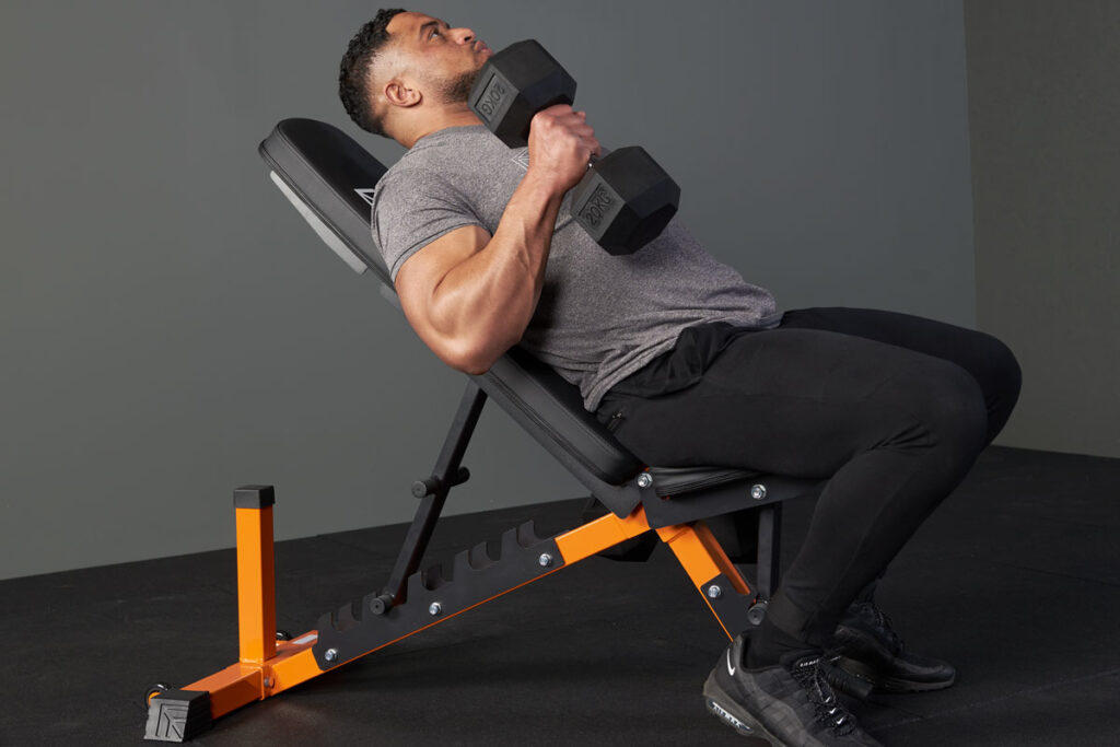 Man performing an incline dumbbell bicep curl with a Mirafit hex dumbbell and adjustable weight bench