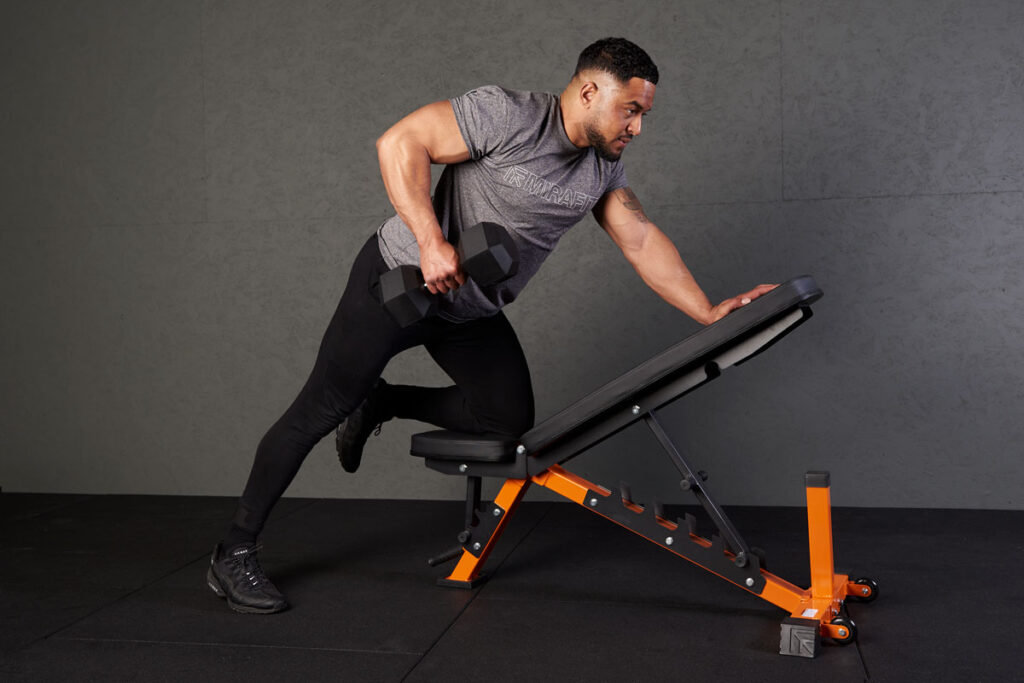 Man performing a single arm row using Mirafit hex dumbbells and adjustable weight bench