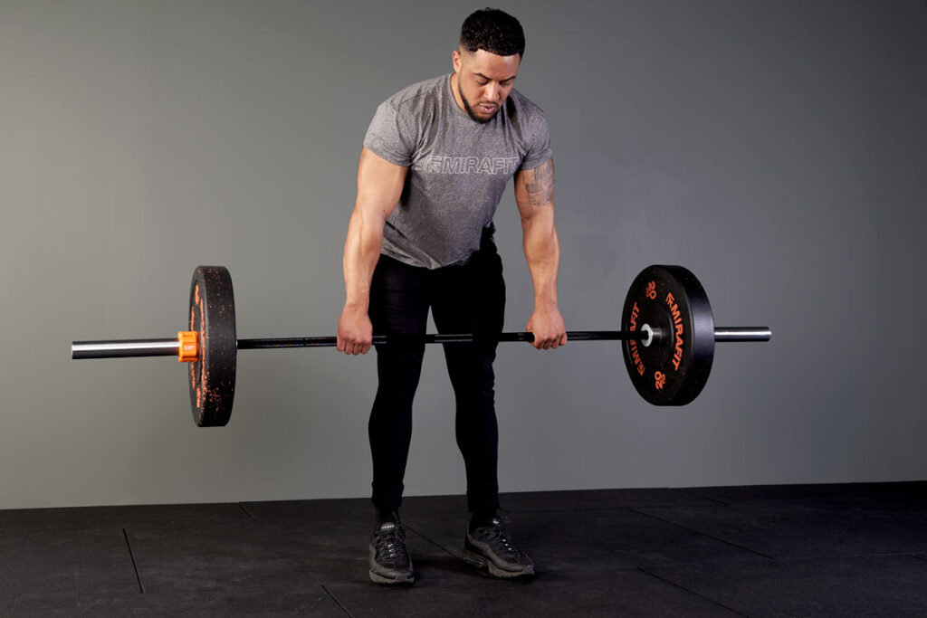 Man performing a stiff leg Romanian deadlift (Hip dominant) with Mirafit 20kg weight plates