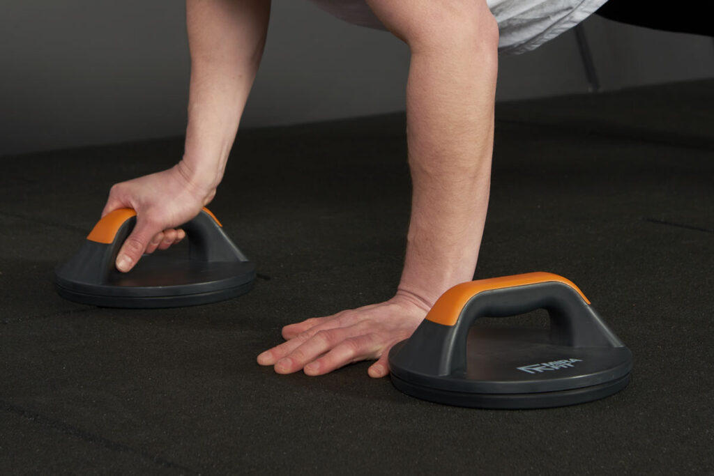 Mirafit Rotating Push Up Bars woman performing a unilateral raised push up using Mirafit rotating push up bars