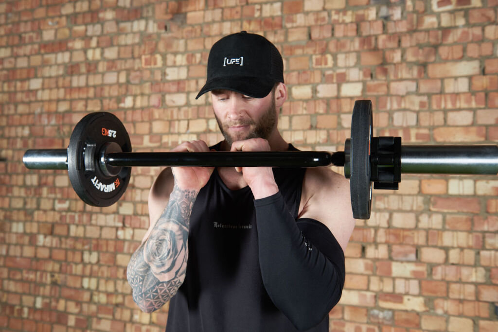 Tricep bar bicep curl Man doing a tricep bar bicep curl using Mirafit 2.5kg weight plates