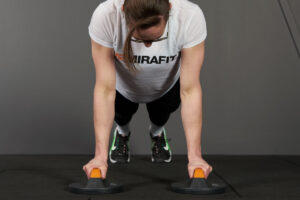 woman performing a push up with a pair of Mirafit rotating push up bars