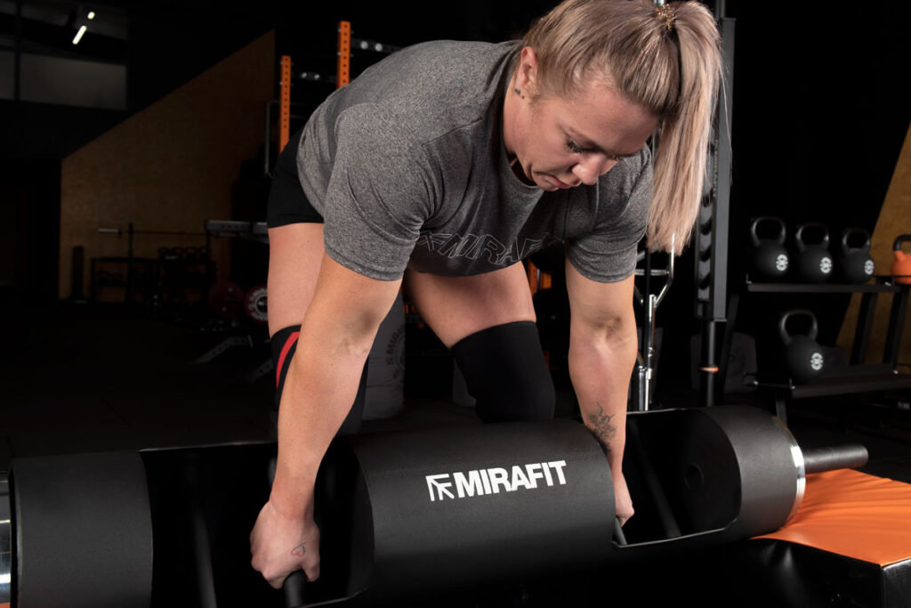 Mirafit Extra Thin Steel Olympic Plates Strongwoman Donna Moore showing the neutral grip on a Mirafit 10" Strongman Log