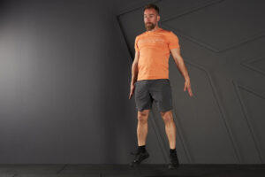 Man doing a jump squat in a Mirafit t-shirt