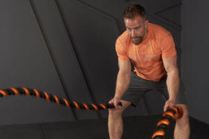 Man doing a battle rope HIIT workout with a Mirafit Battle Rope