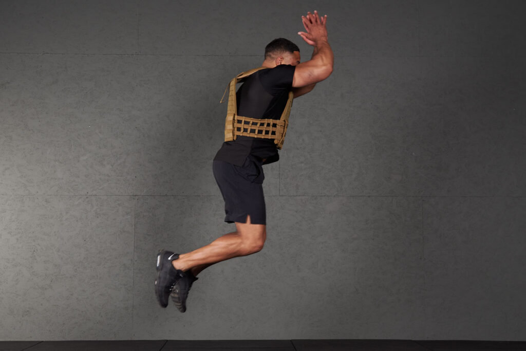 Bound Jump Man doing a bound jump with a Mirafit Tactical Weight Vest