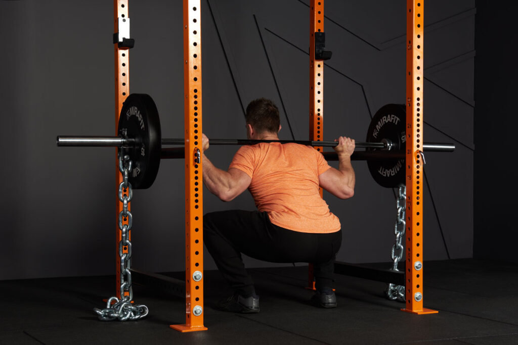 Man doing a barbell and chain resistance squat