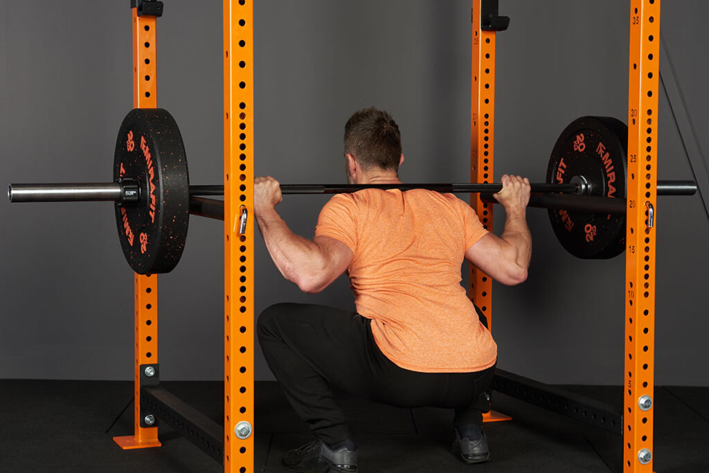 Pin Squat Man doing a pin squat in a Mirafit M3 Power Rack