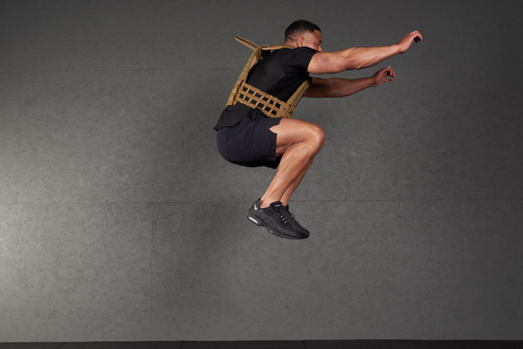 Tuck Jump Man doing tuck jumps with a Mirafit Tactical Weight Vest