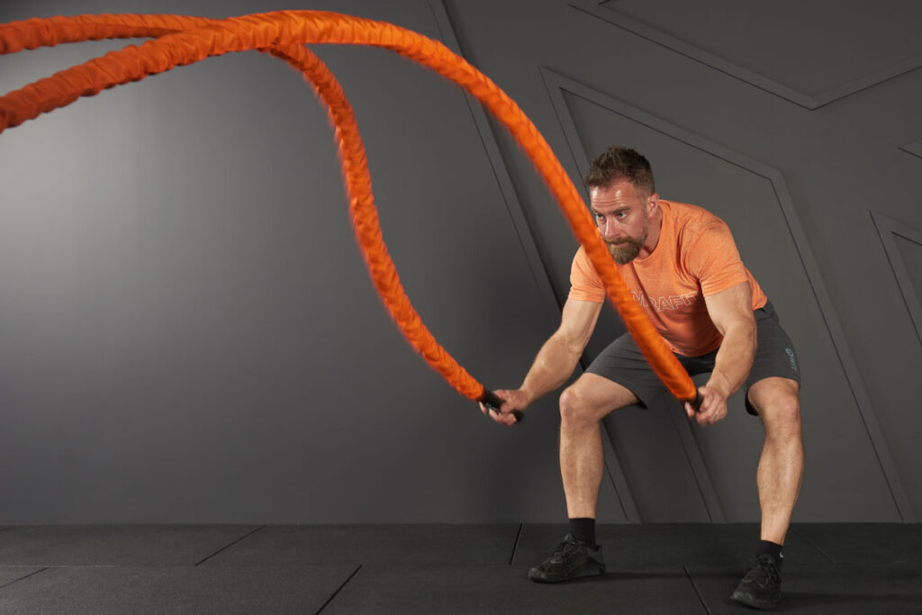 Battle Rope Power Slams Man doing battle rope power slams with a Mirafit Battle Rope