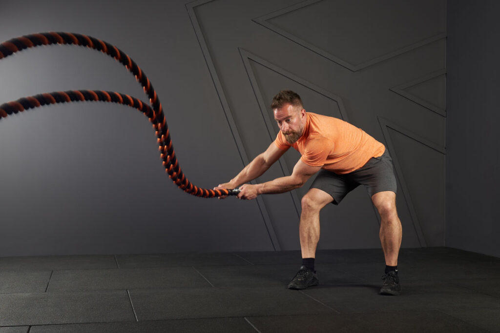 Man doing side slams with a Mirafit Battle Rope