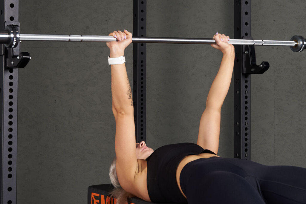 Close Grip Bench Press Woman doing a close grip bench press with a Mirafit Barbell