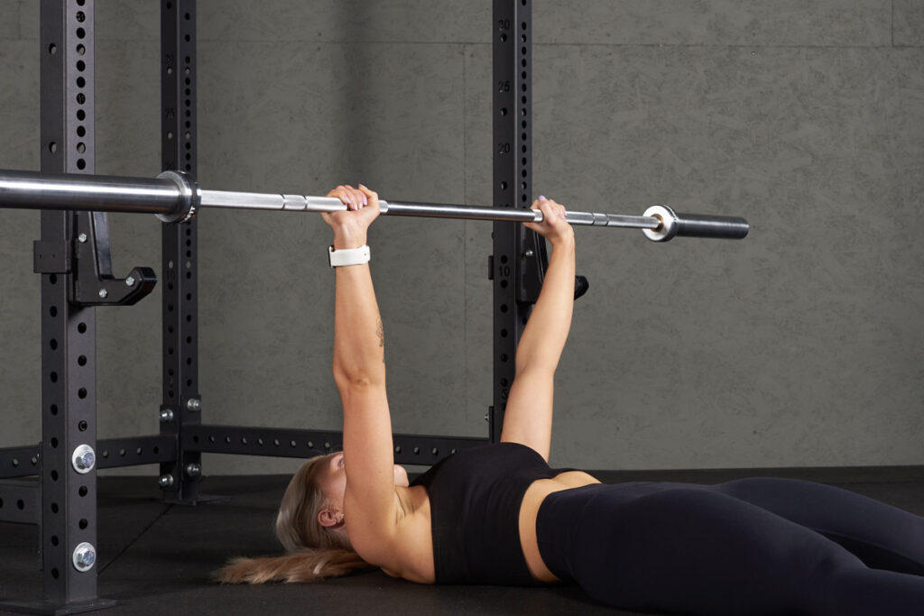 Barbell Floor Press Woman doing a barbell floor press with a Mirafit Barbell