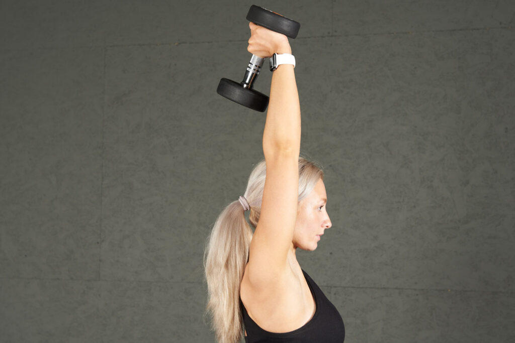 Single Arm Overhead Dumbbell Tricep Extension woman doing a single arm overhead dumbbell tricep extension with a Mirafit Rubber Dumbbell Set