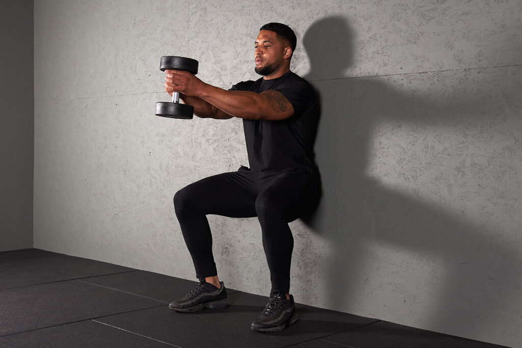 Man Doing a Dumbbell Wall Sit with a Mirafit Dumbbell