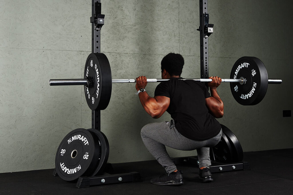 Man doing a light squat drop set with Mirafit 25kg Bumper Plates