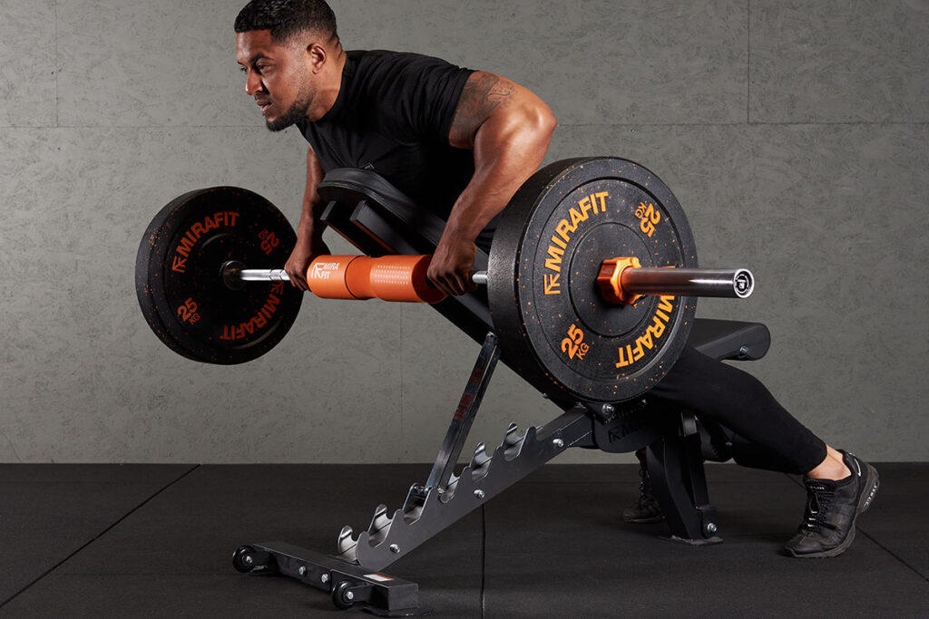 Incline Bench Prone Row Man doing an incline bench prone row with Mirafit 25kg bumper plates