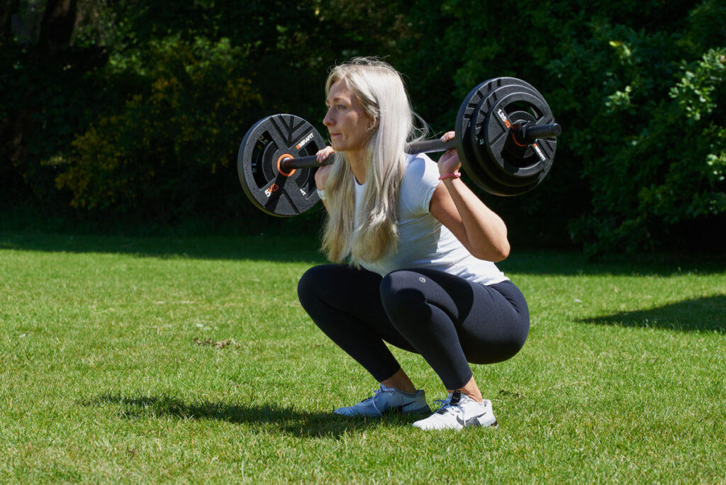 Back Squat Woman doing a back squat with a Mirafit Studio Pump Set