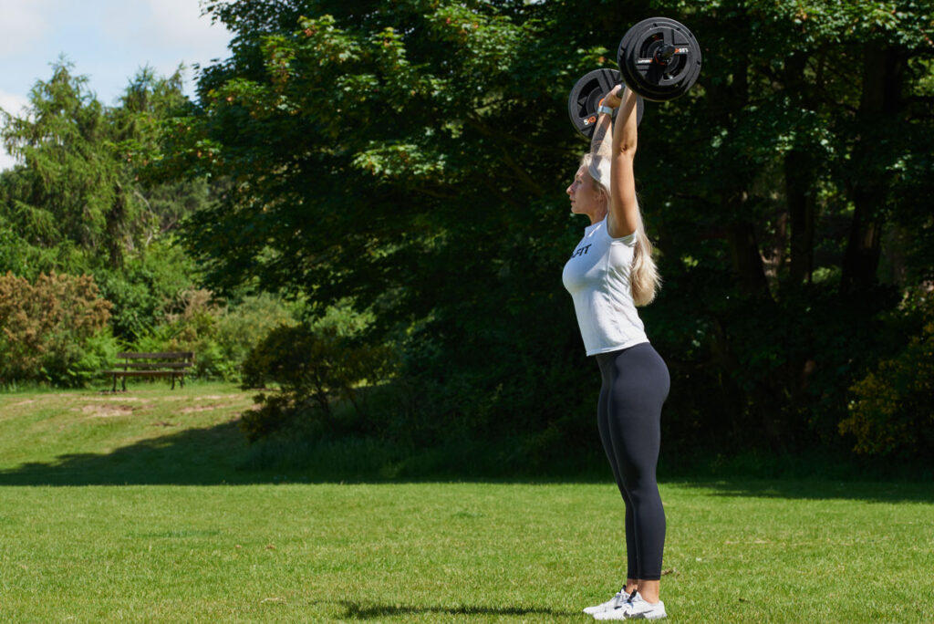 Push Press Woman doing a push press with a Mirafit Studio Pump Set