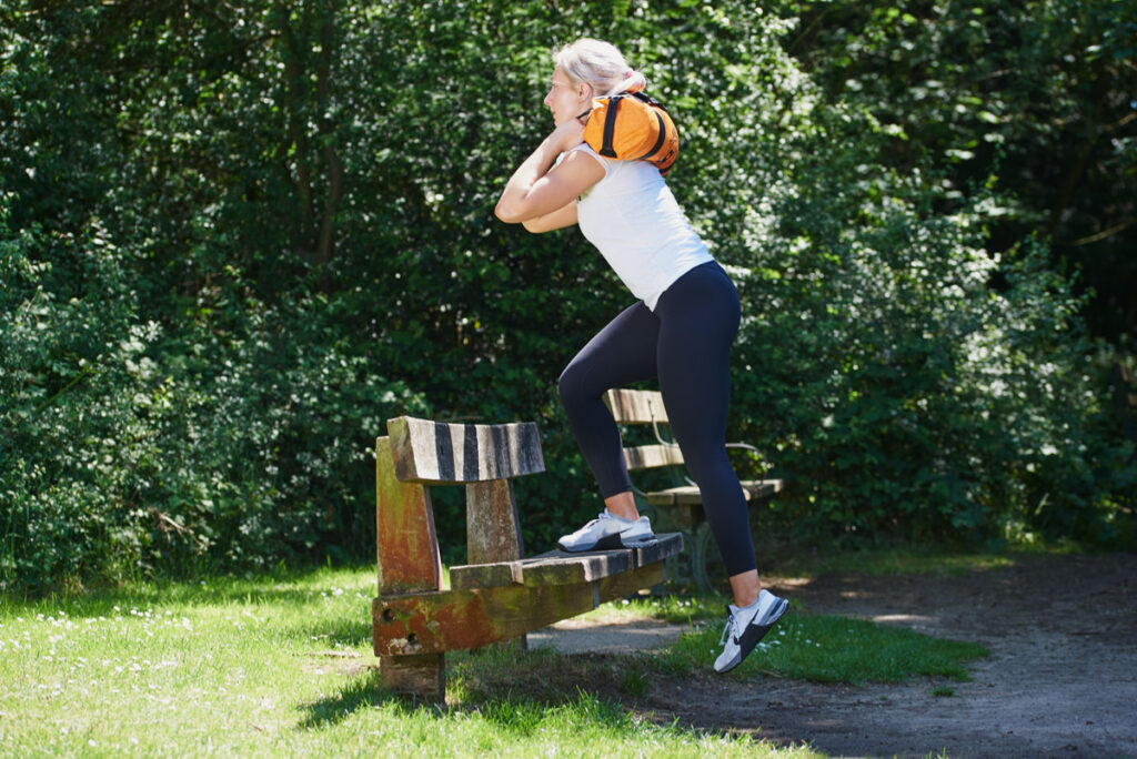 Woman doing a step up with a Mirafit Gym Sandbag