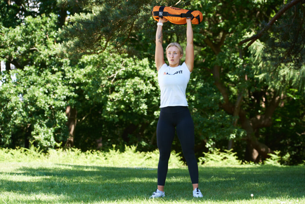 Woman doing a thruster with a Mirafit Gym Sandbag