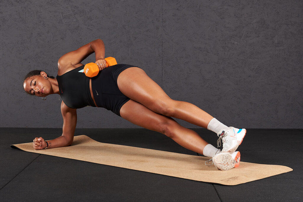 Side planks with hip lifts Woman doing side planks with hip lift with Mirafit Soft Touch Dumbbells