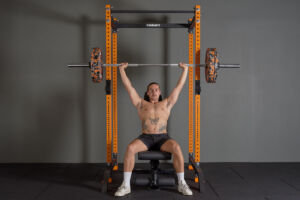 Man performing a barbell press in a Mirafit Power Rack