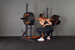Woman squatting in a Mirafit M130 Adjustable Squat and Bench Press Rack