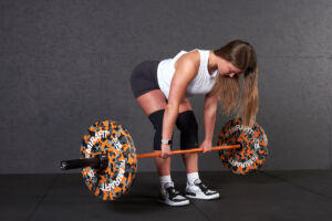 Woman doing a Romanian Deadlift with Mirafit Orange Camo Bumper Plates