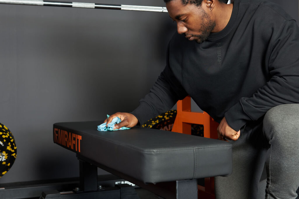 Man cleaning his Mirafit M3 Flat Weight Bench