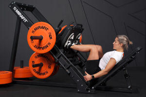 Woman using a Mirafit Leg Press Machine