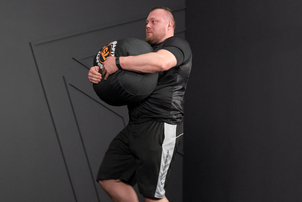 Adam Bishop Carrying a Mirafit Heavy Sack Style Sandbag for Strongman Training