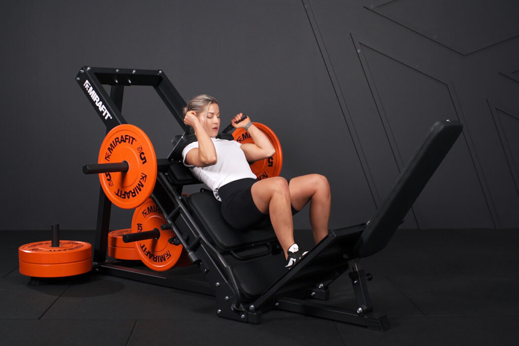 Woman using a Mirafit Hack Squat Machine