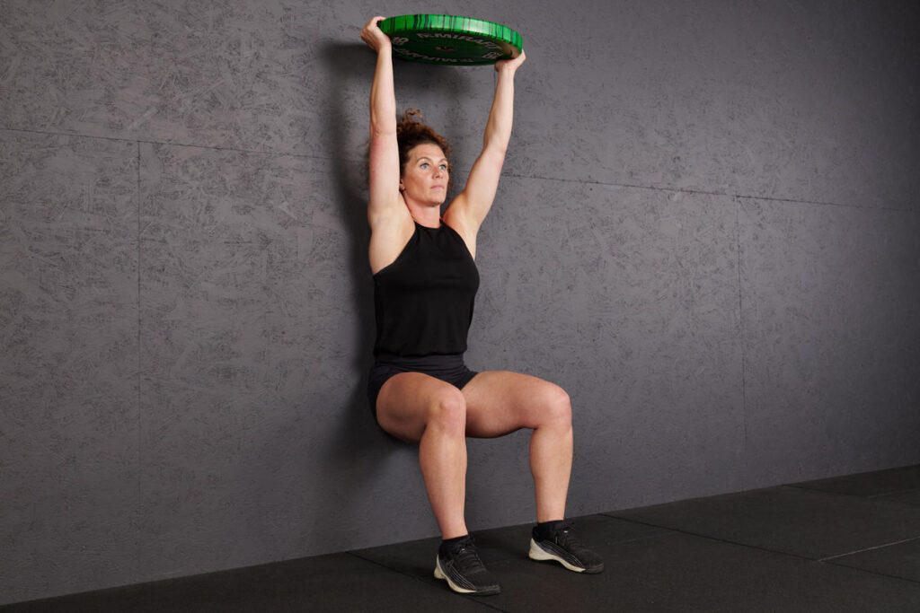 Wall sit with overhead plate hold using Mirafit Marbled Bumper Plate