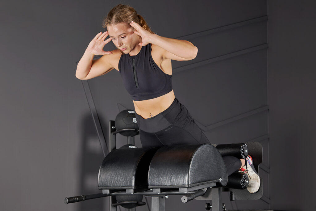 Woman performing a hyperextension on a Mirafit GHD Machine