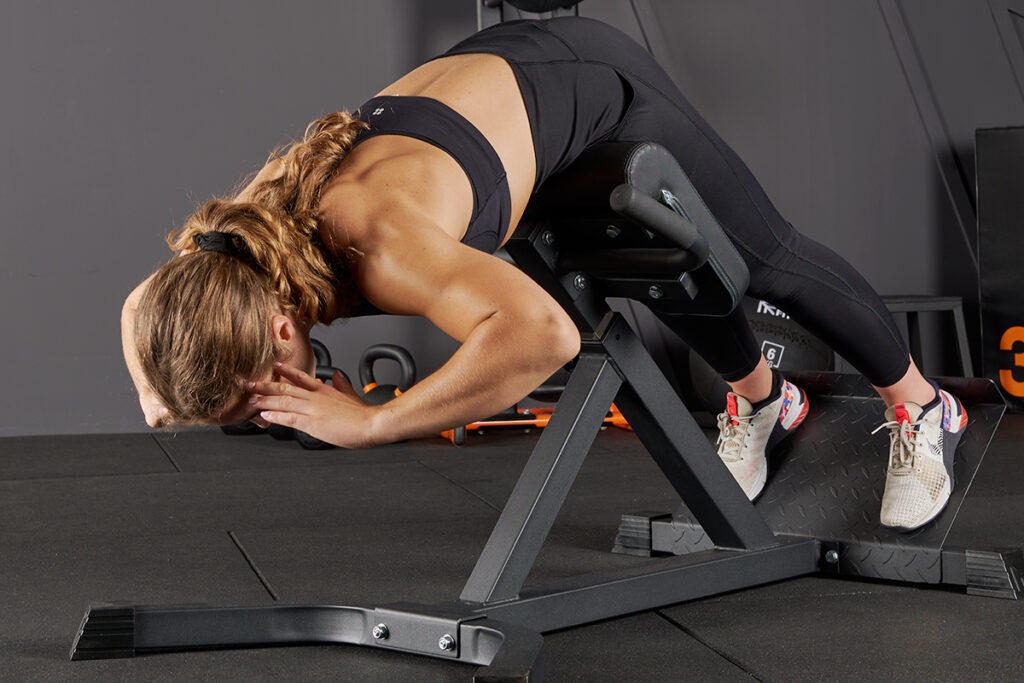 Woman performing a hyperextension on a Mirafit Hyperextension Bench