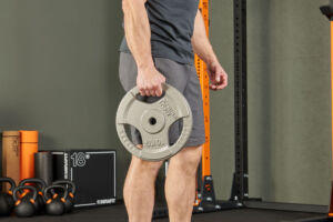 Man holding Mirafit Tri Grip Weight Plate