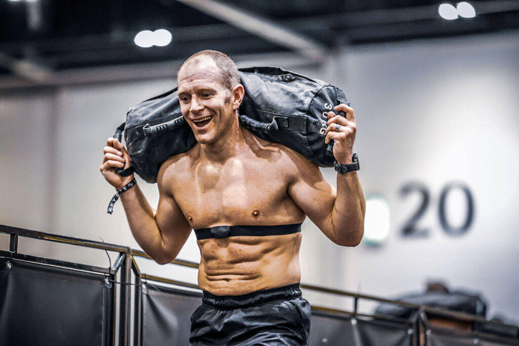 Man running with a gym sandbag