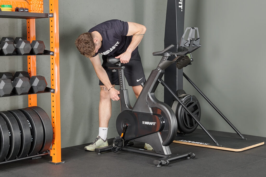 Mirafit Exercise Bike Man adjusting a Mirafit Exercise Bike