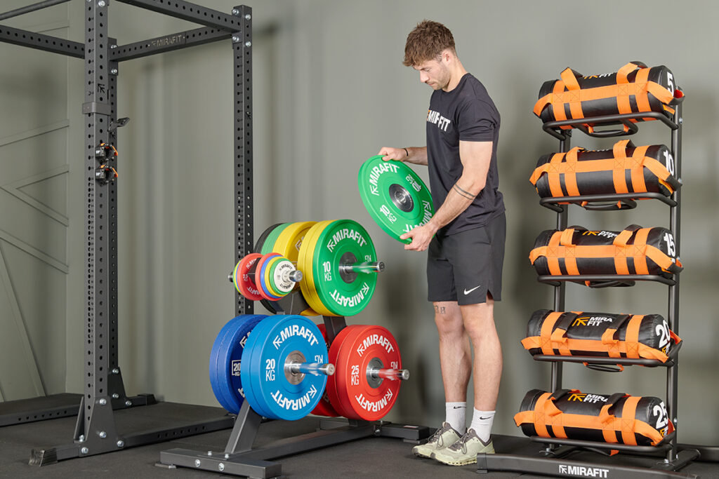 Mirafit Bumper Plate Weight Storage Tree Man loading a Mirafit Bumper Plate Weight Storage Tree