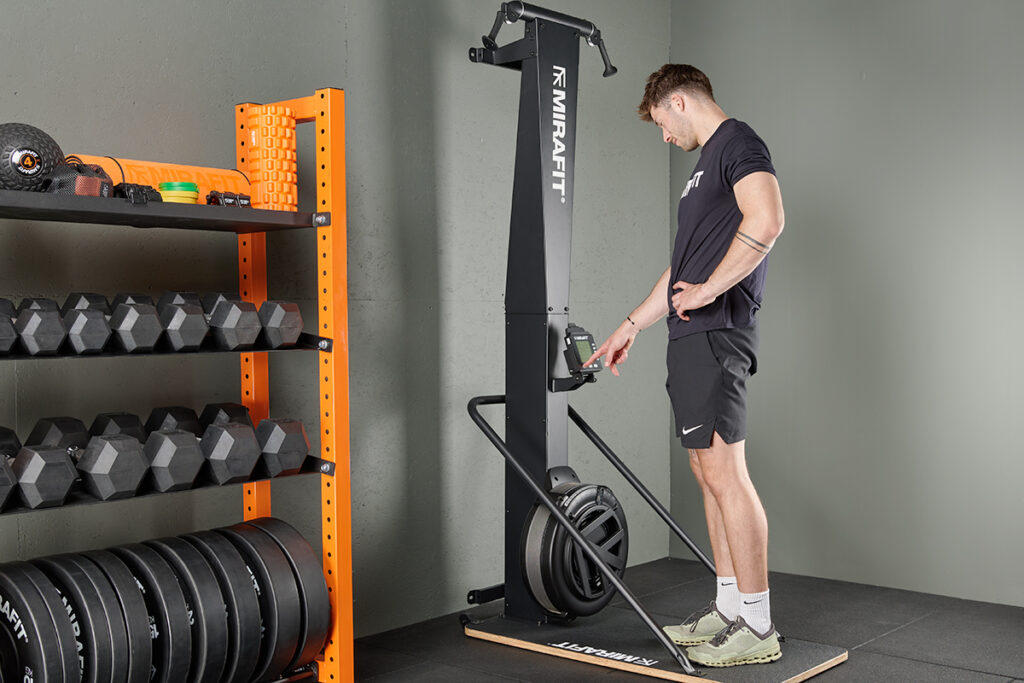 Man programming a Mirafit Ski Machine