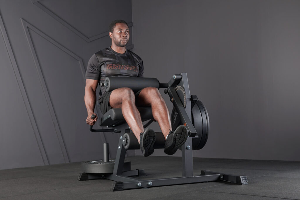 man using Mirafit Leg Curl and Extension Machine