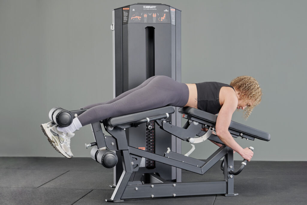 Woman using Mirafit Leg Curl and Extension Machine with Weight Stack