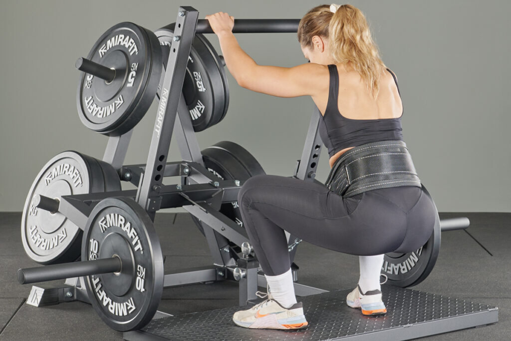 woman using Mirafit Belt Squat Machine