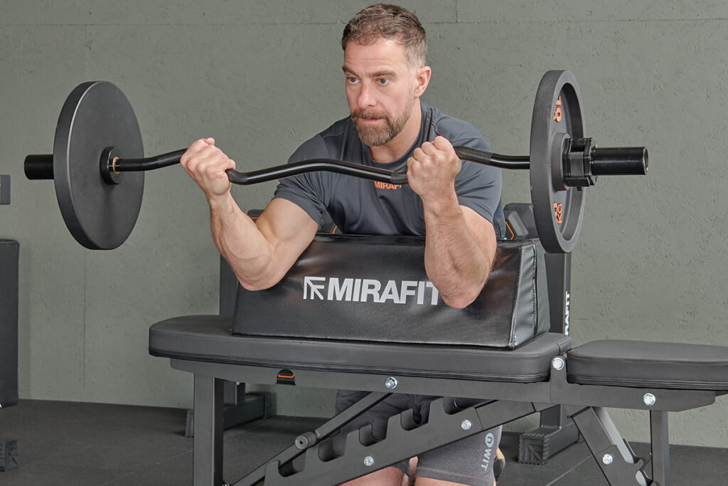 Mirafit Bicep Isolator preacher curl using a Mirafit Bicep Isolator